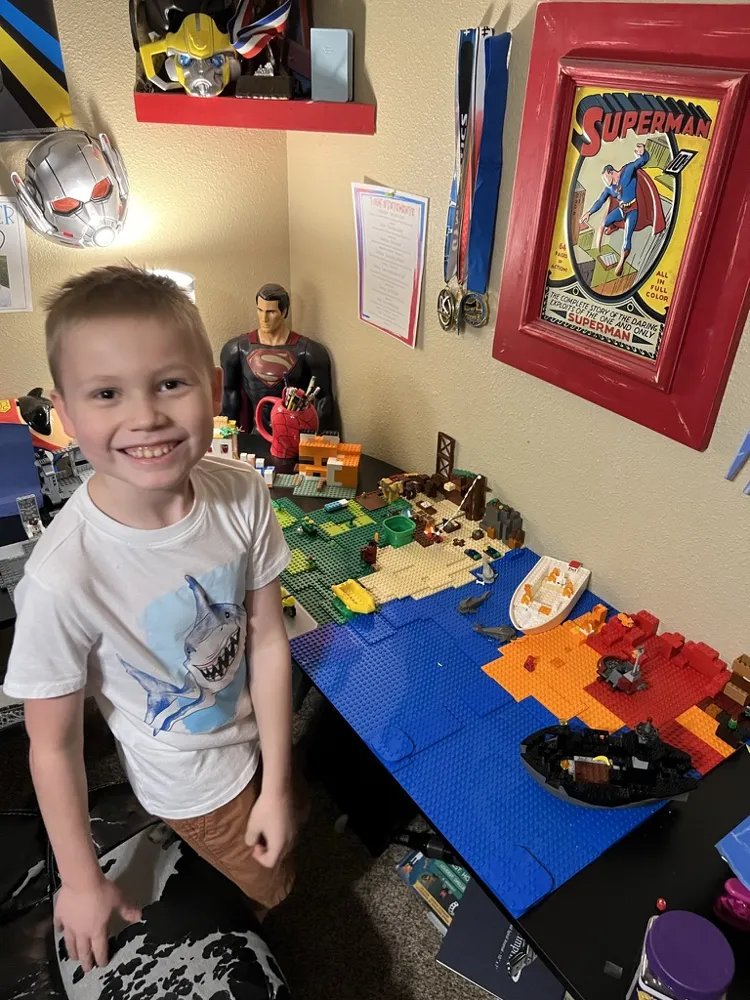 CJ smiling next to a big brick island and ocean build